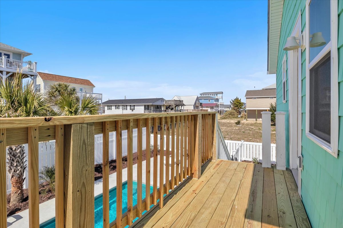 Wooden deck offering views of the neighborhood and glimpsing the pool below.