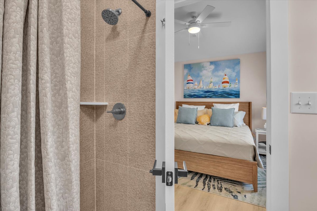 Your private sanctuary awaits with a refreshing shower and cozy bedroom featuring nautical artwork to inspire seaside dreams.