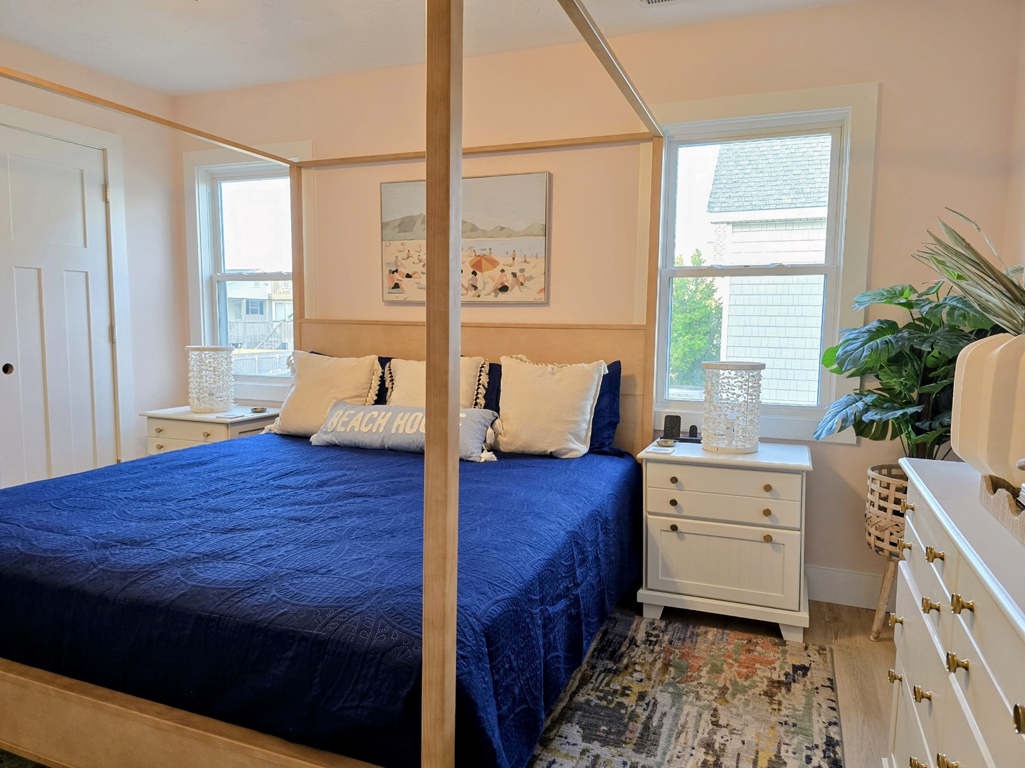 Drift into peaceful sleep in your elegant canopy bed, surrounded by coastal charm and natural light streaming through windows.