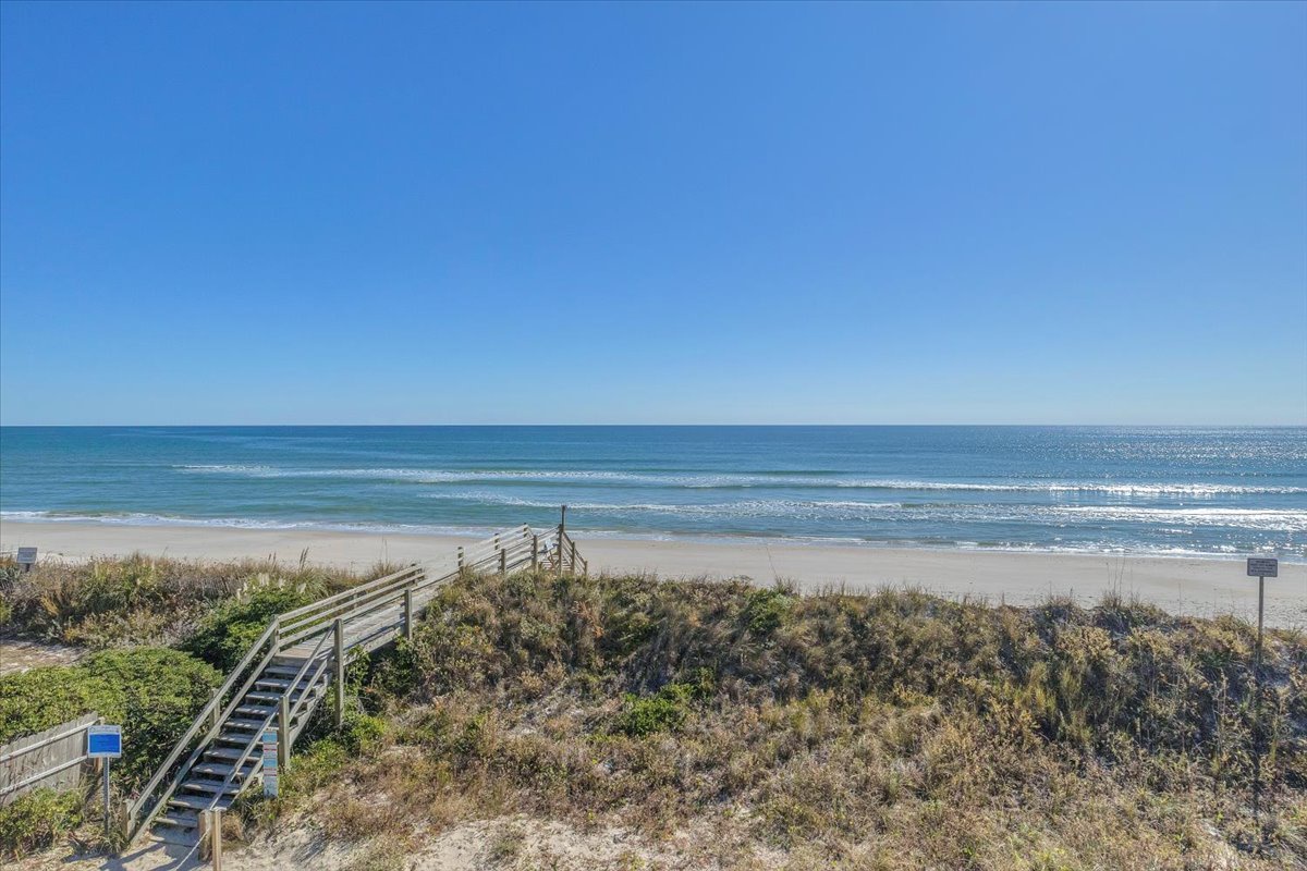 Pristine beach with wooden boardwalk leading to endless ocean views and rolling waves.