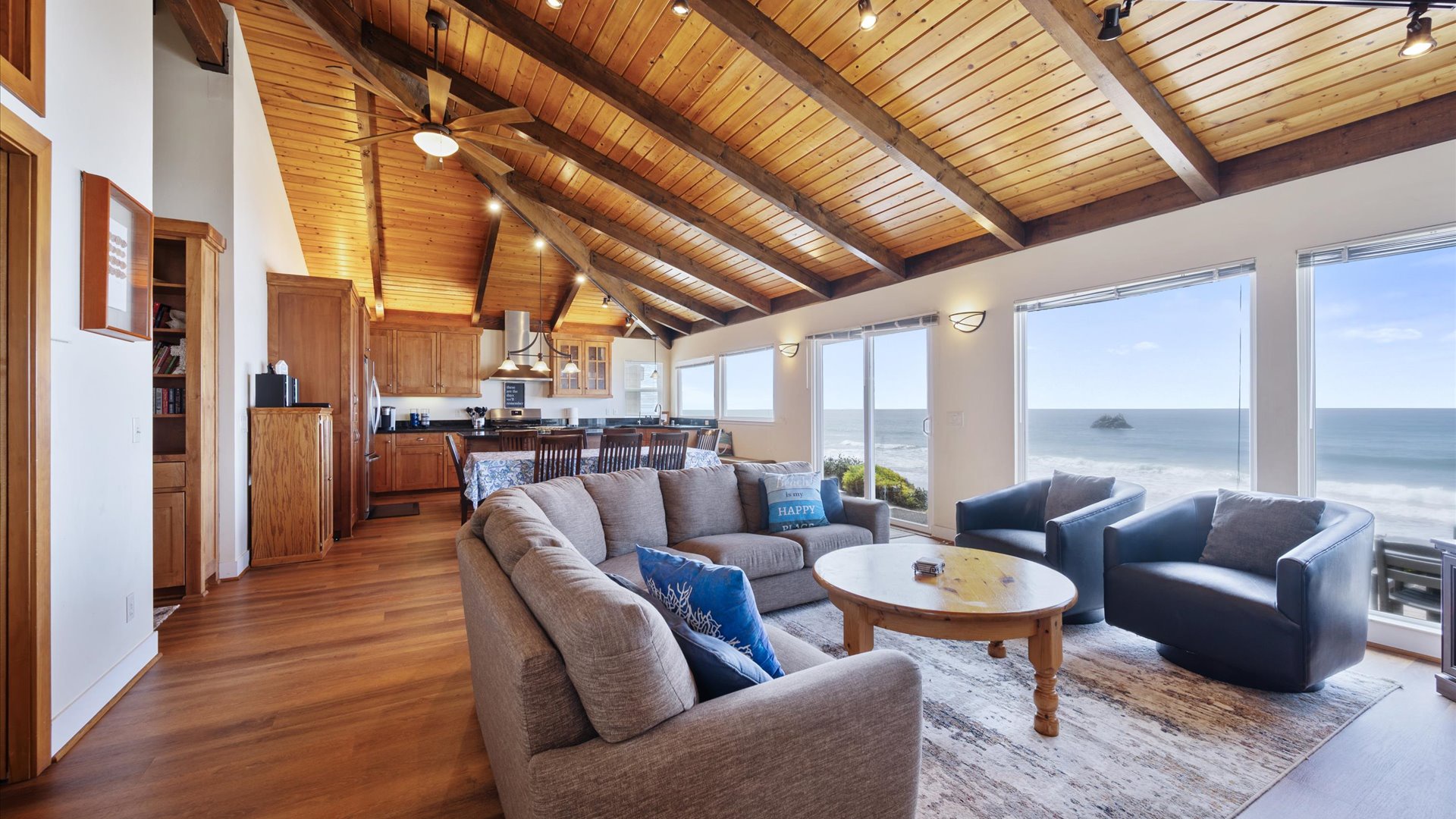 Living area opens to the dining and kitchen areas with sweeping ocean views through floor-to-ceiling windows
