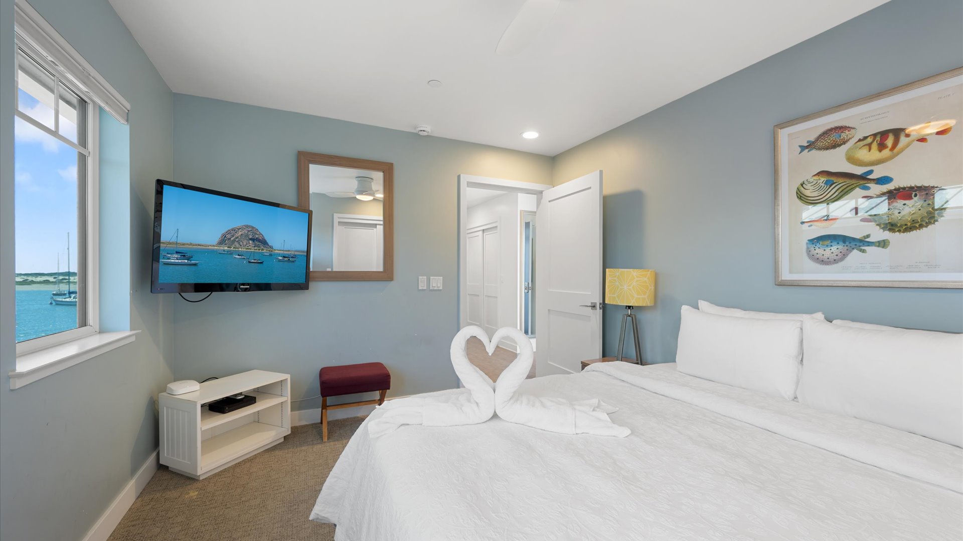 The bedroom has a fireplace and ceiling fan along with flat screen tv.