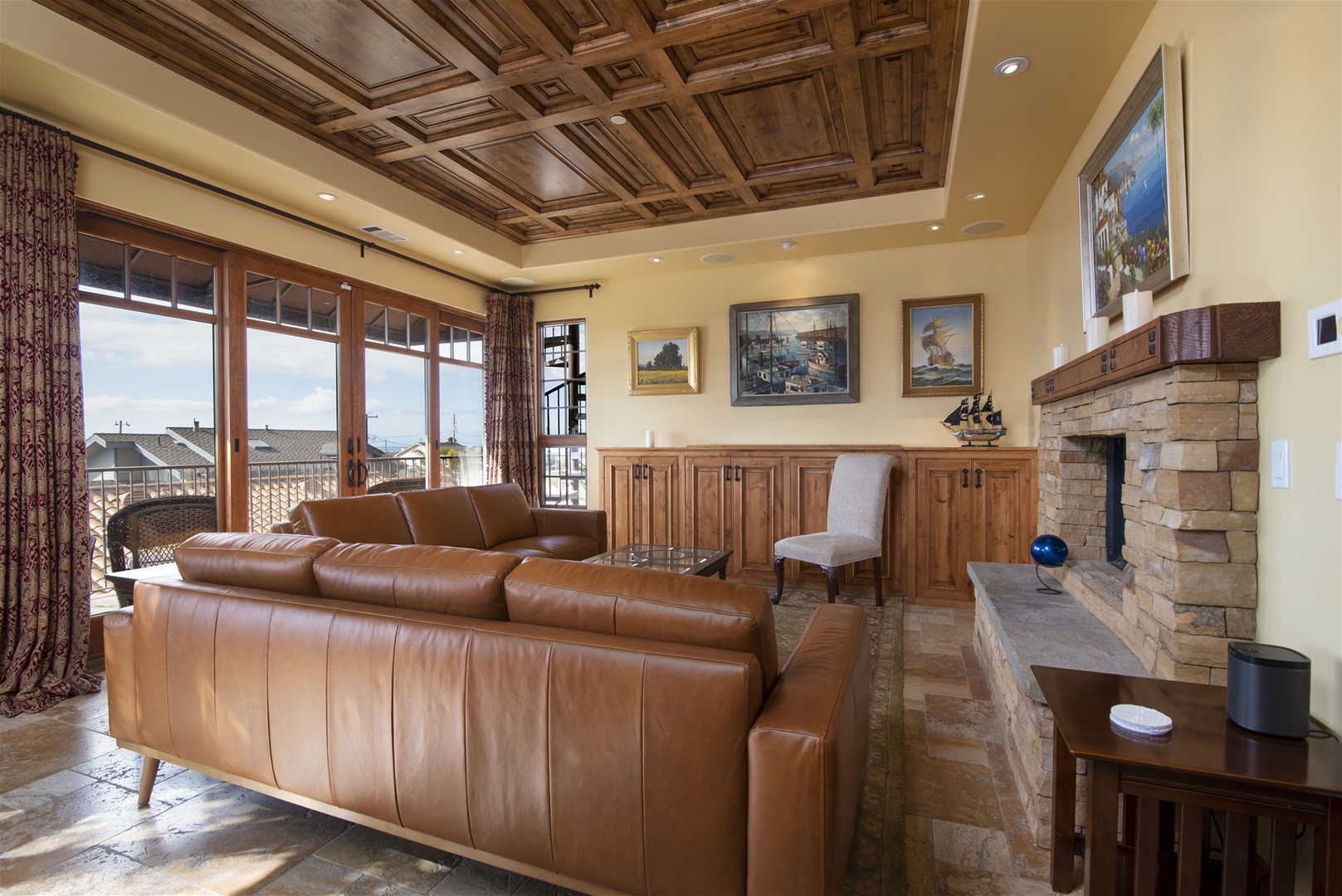 The living room has a large pop-up TV and panoramic windows featuring ocean views