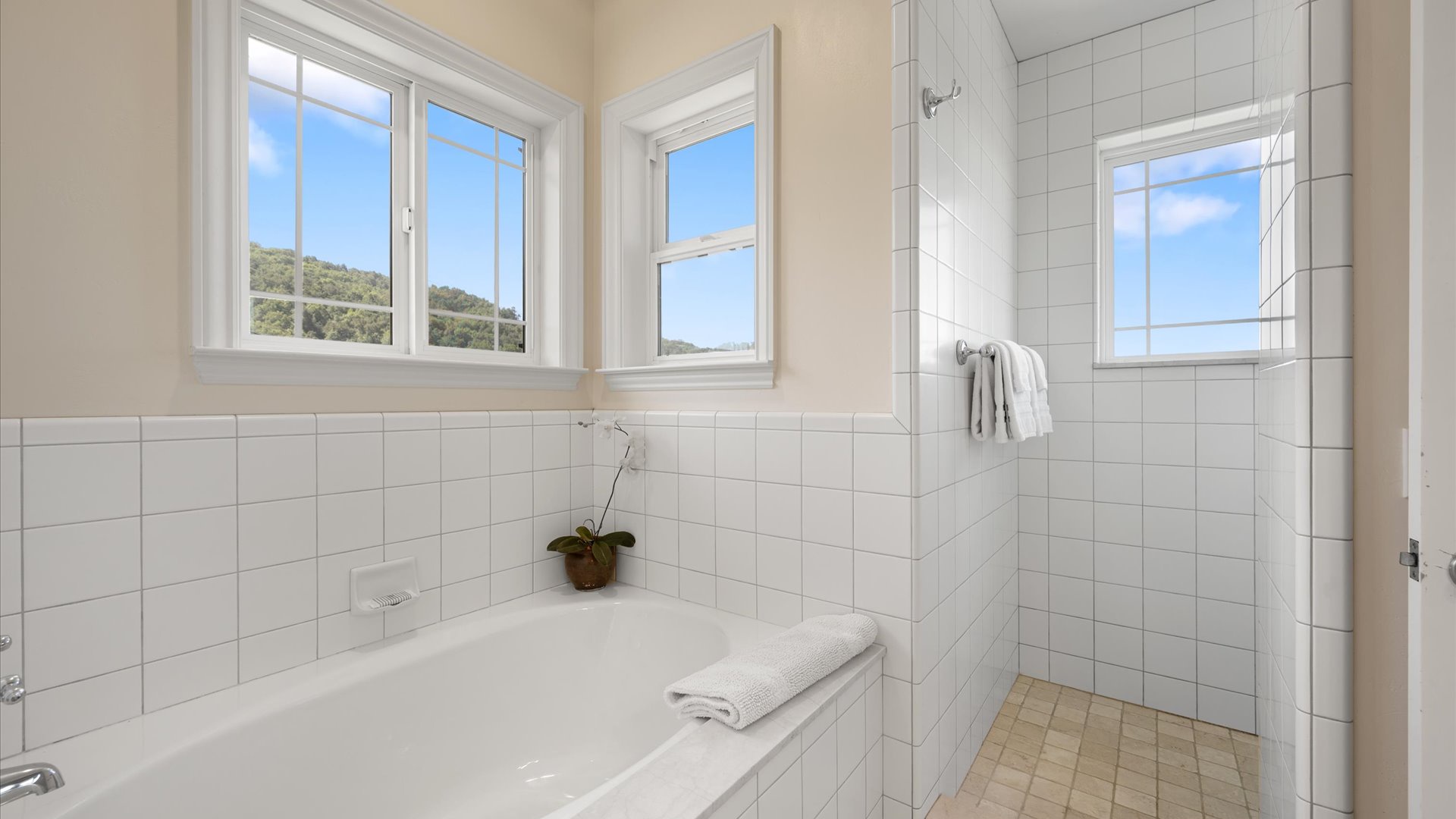 Soak in the tub or rinse off in your private walk-in shower, both bathed in natural light from windows overlooking peaceful hillside greenery.