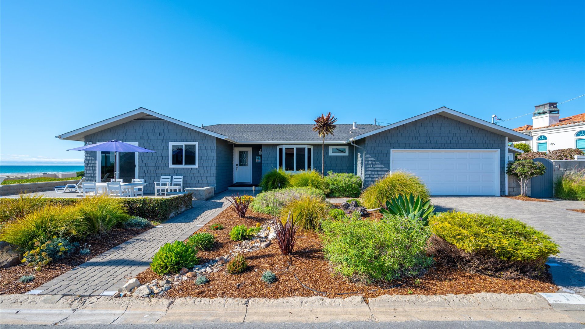 Beautiful landscaping and an oceanfront patio welcome you to this lovely oceanfront vacation rental