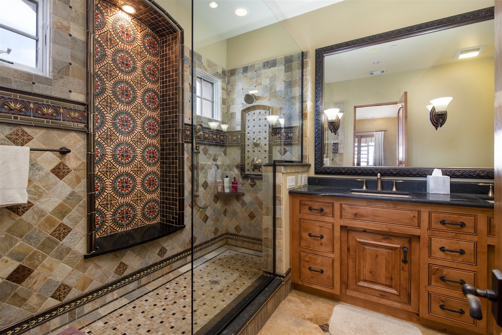 Stunning step in shower in master bath with tiles replicated from Hearst Castle