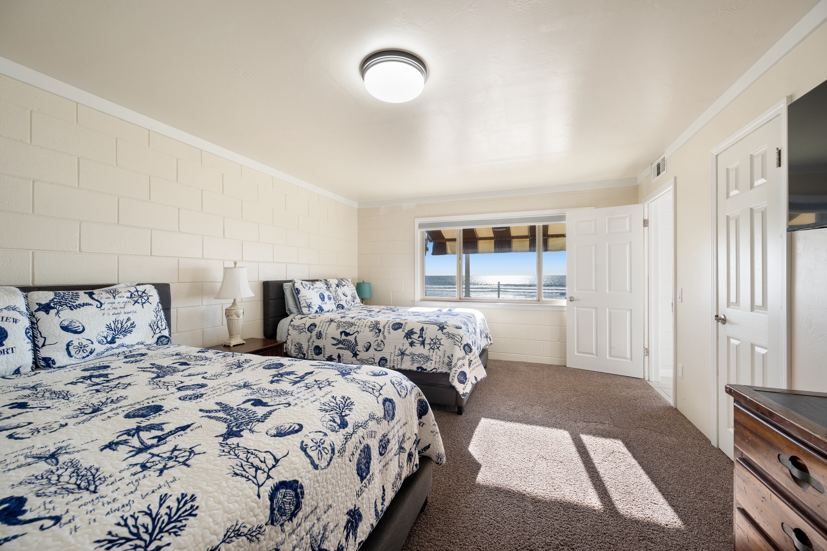 Windows with views of the ocean in second downstairs bedroom