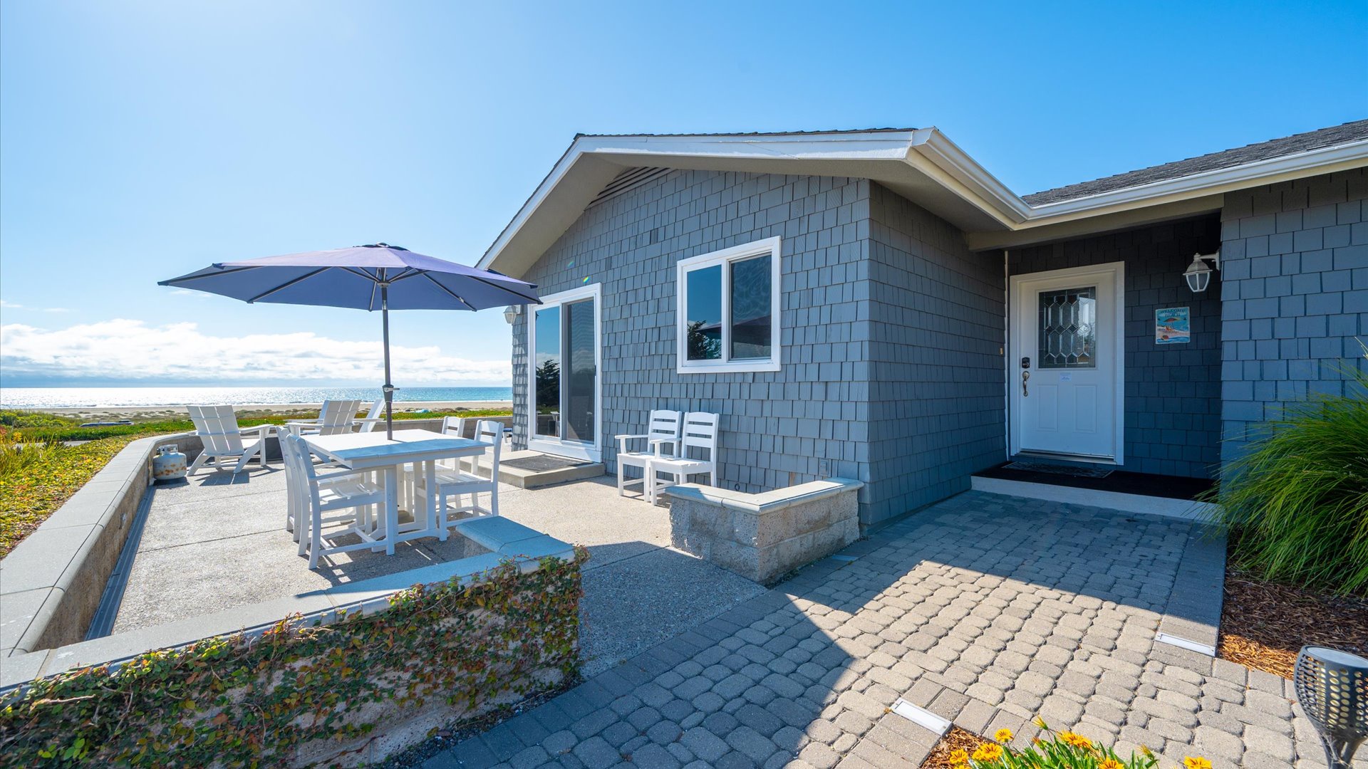 Front patio with dining table and umbrella, one of the many outdoor spaces to enjoy
