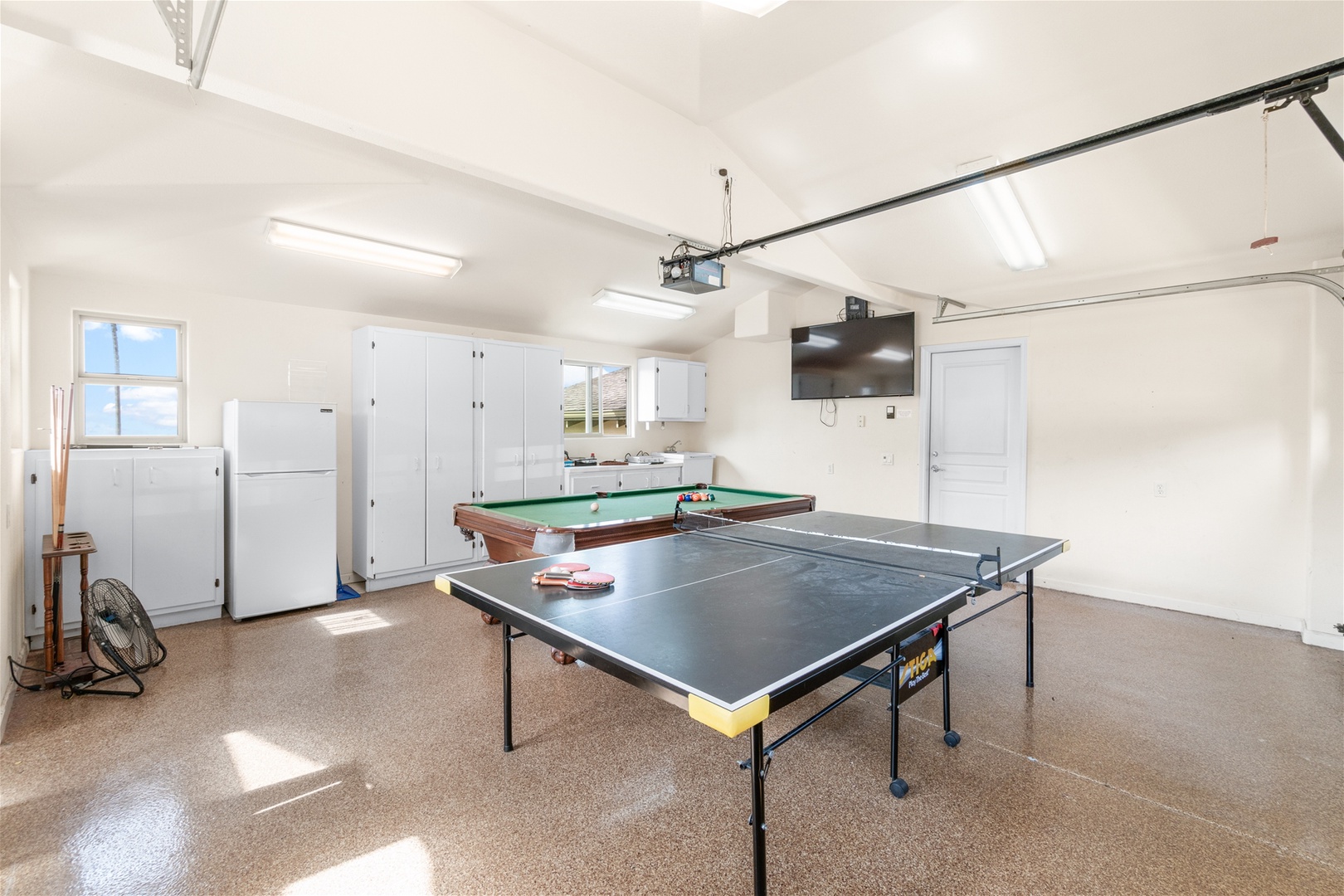 Clean 2 car garage w/ epoxy flooring has been converted to a game room