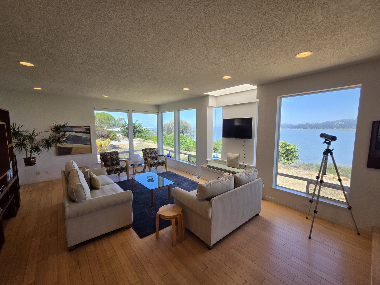 Unwind in your light-filled living room where panoramic windows frame breathtaking coastal views.