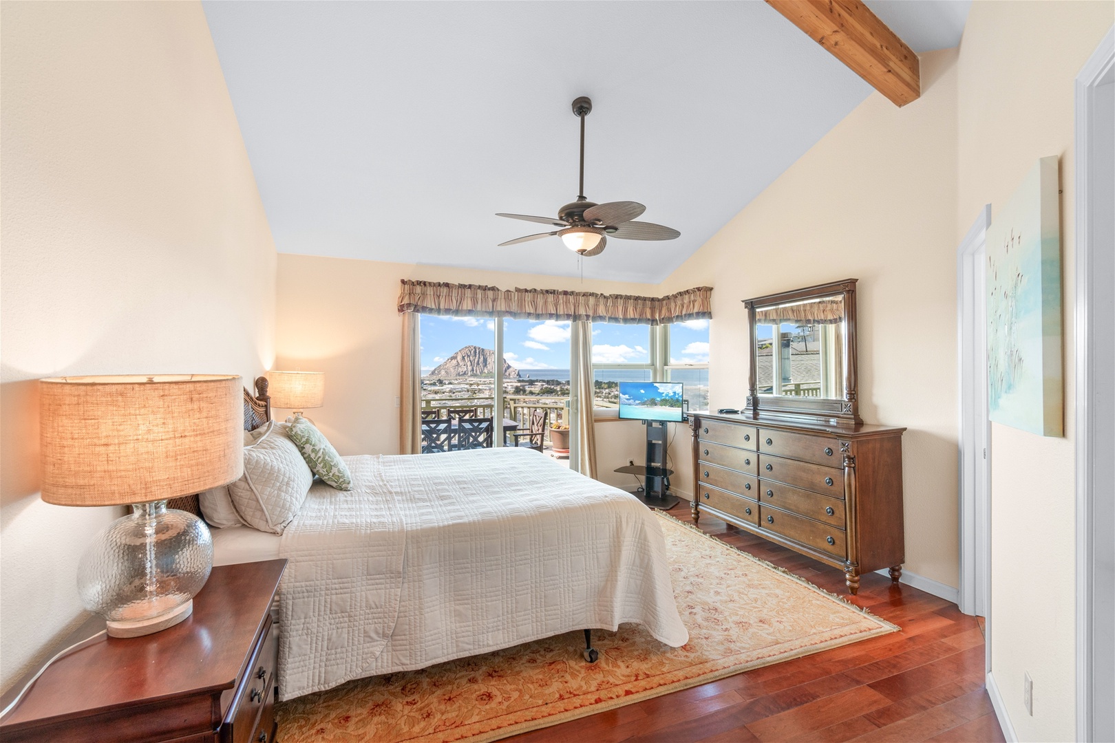 The Master Bedroom on the main floor has a king-size bed, access to the outdoor patio with views of the Pacific, a large walk-in closet and a private bathroom