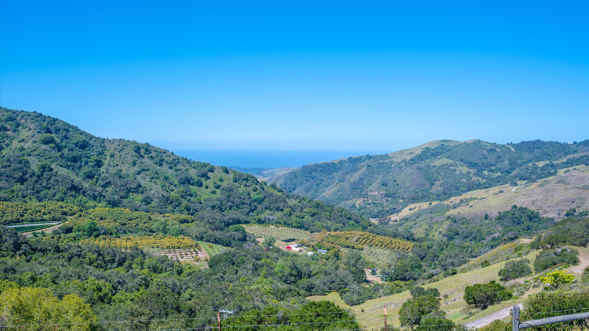 The view from this home: a picturesque landscape of valleys, orchards, and distant ocean views