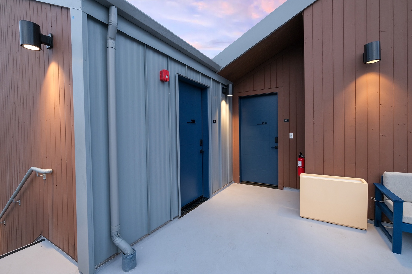 Small upstairs patio with seating outside the front doors of unit 201 & 202
