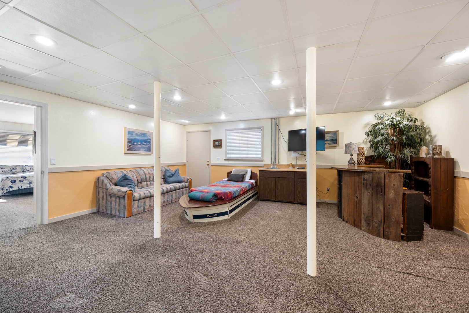 Den features TV, bar area, and additional seating area for gathering