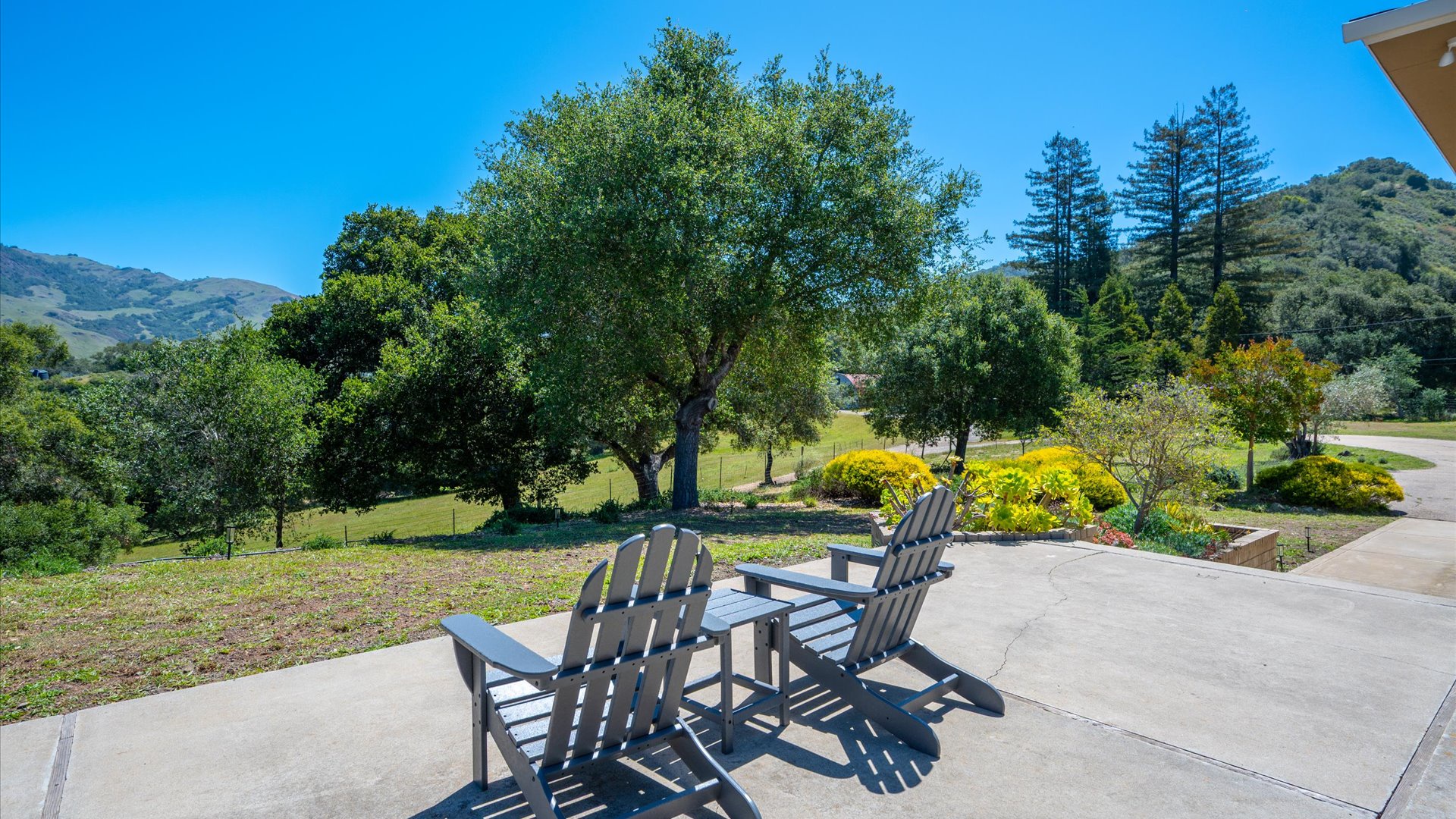 Adirondack chairs and ample seating in the outdoor areas of this home make soaking in the views a breeze