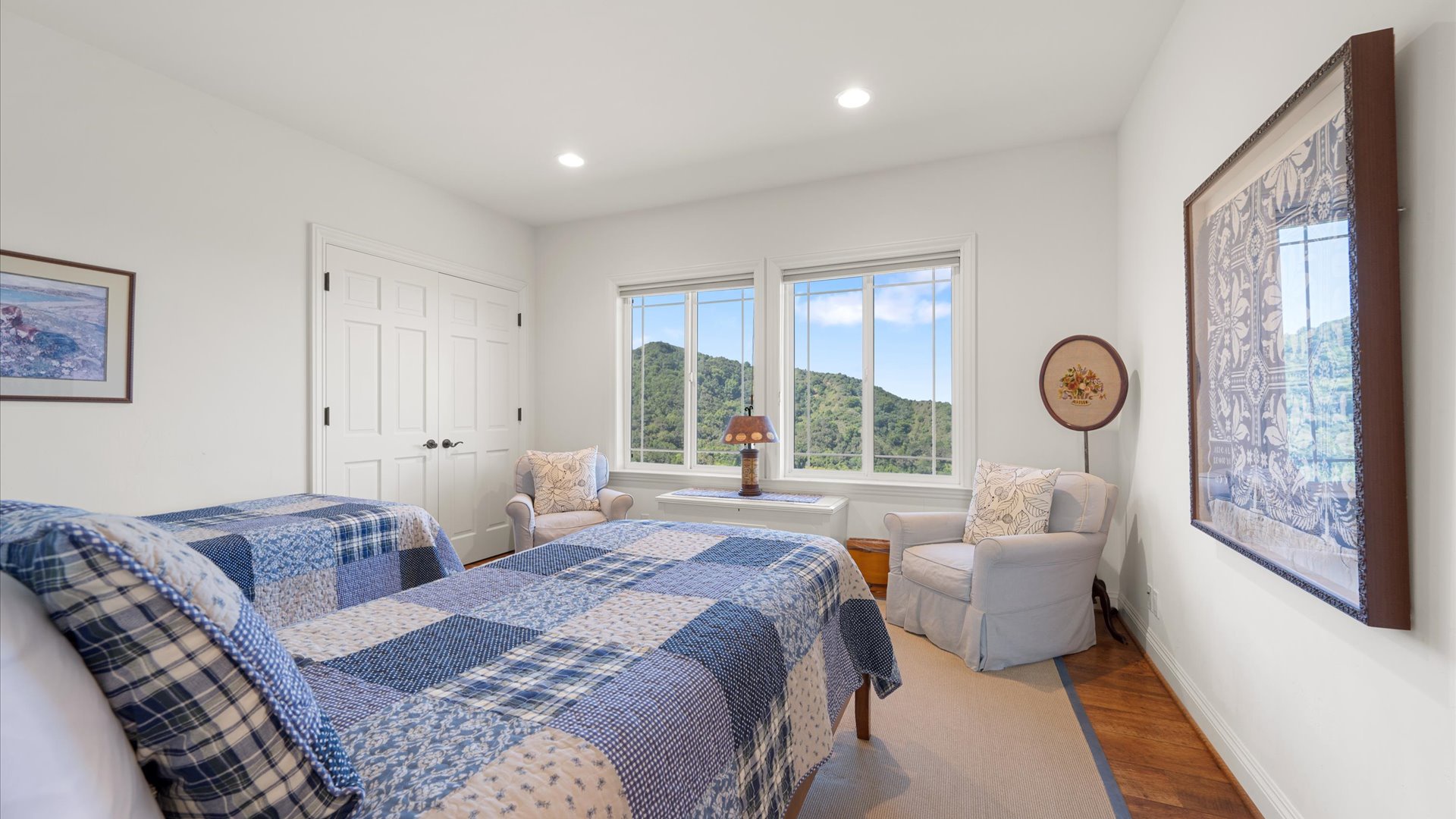 The west twin bedroom also features natural lighting and additional comfortable arm chairs for relaxing or cozying up with your favorite book