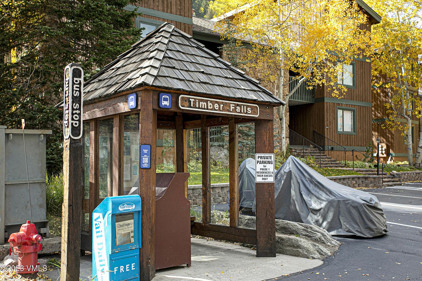Property entrance at Timber Falls with seasonal autumn foliage and nearby shuttle stop serving the area.
