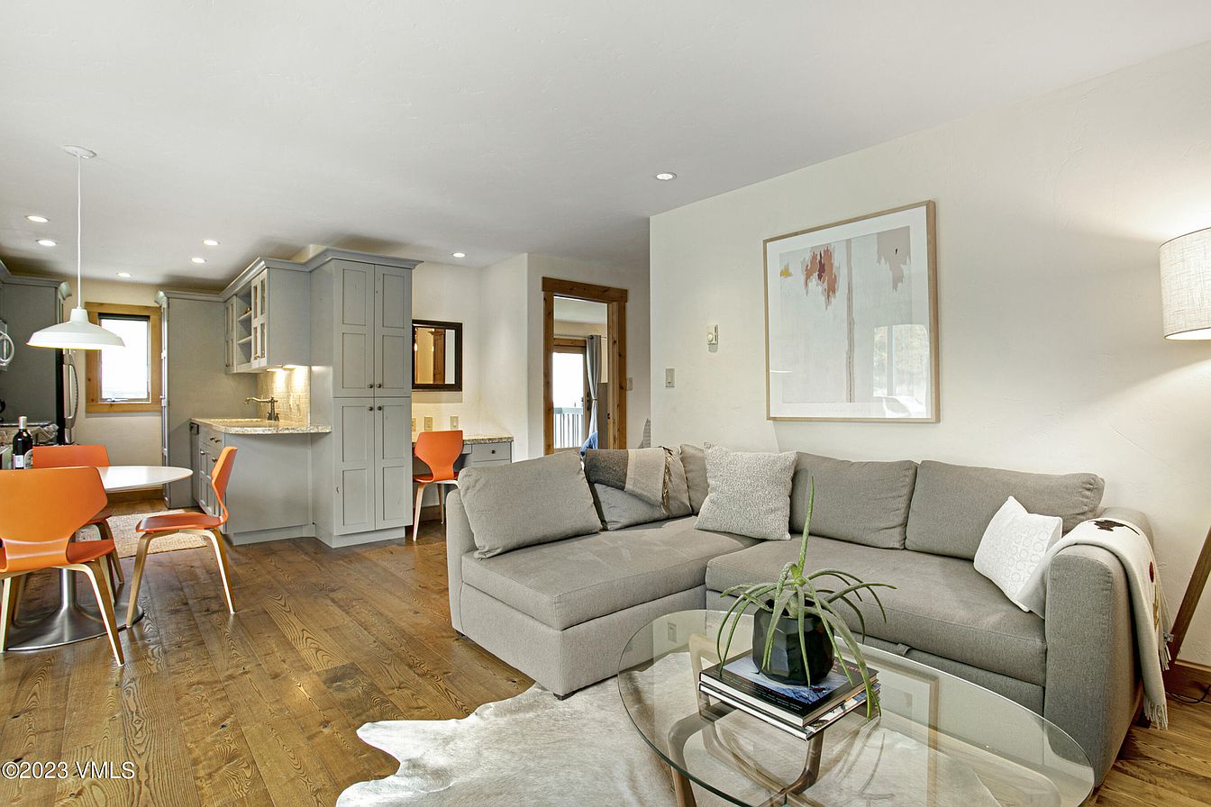 Bright open living space flows seamlessly into a fully equipped kitchen, perfect for gathering after your mountain adventures. Cozy sectional seating invites you to unwind.
