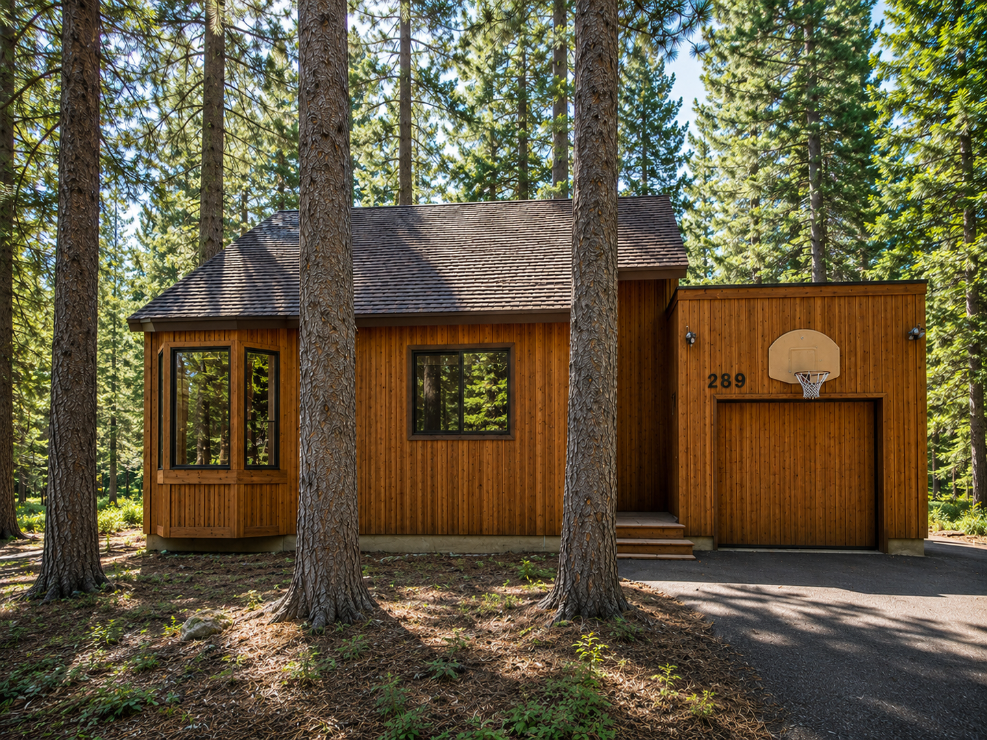 This charming wood-sided retreat is tucked among towering pines, offering a secluded forest setting. The property features a private driveway and attached garage for easy parking and storage.