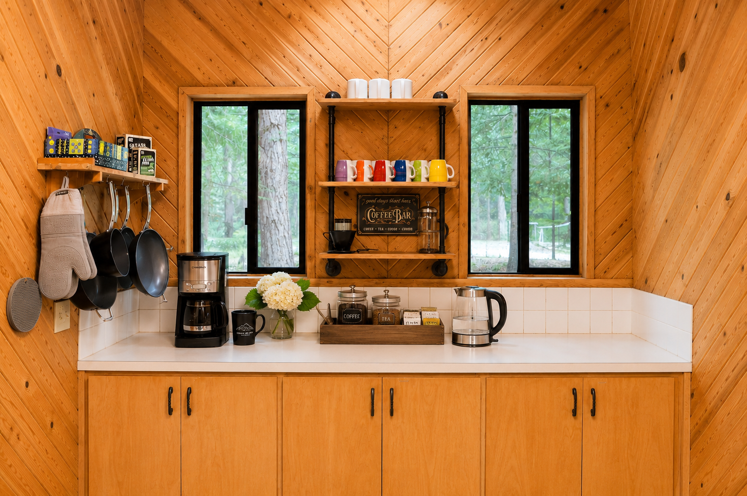 Your own coffee bar awaits, complete with colorful mugs, a French press, and forest views through the windows—perfect for savoring mornings in this cozy cabin retreat.
