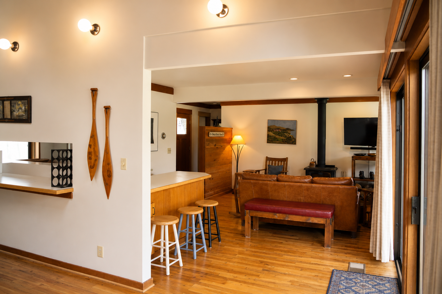 Warm wood tones and thoughtful design invite you to relax in this open, welcoming living space where natural light and coastal artwork create a peaceful retreat atmosphere.