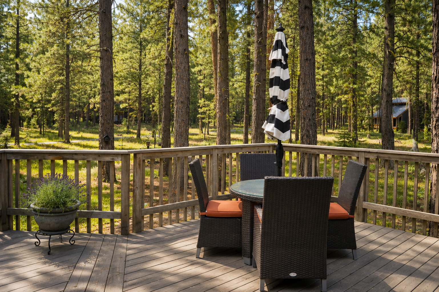 A peaceful forested setting surrounds the property, offering a tranquil natural backdrop visible from the outdoor deck area, ideal for enjoying quiet moments and fresh air.