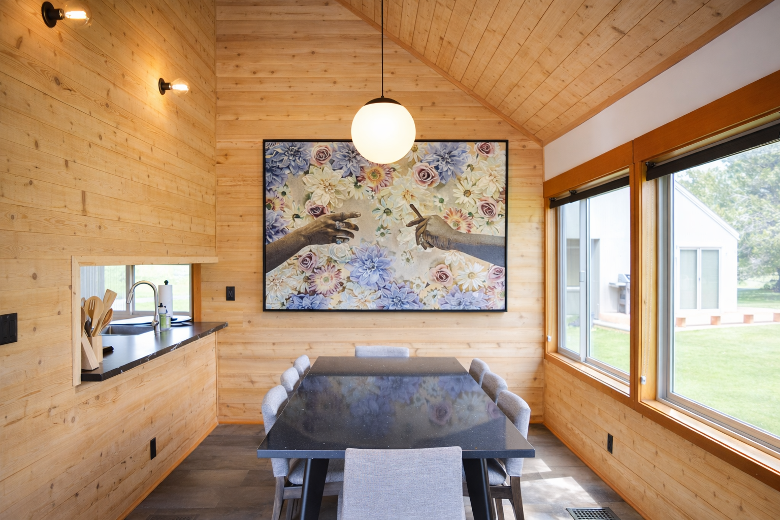 Gather around your stunning dining table beneath warm wood ceilings, where beautiful art and natural light create the perfect atmosphere for memorable meals.