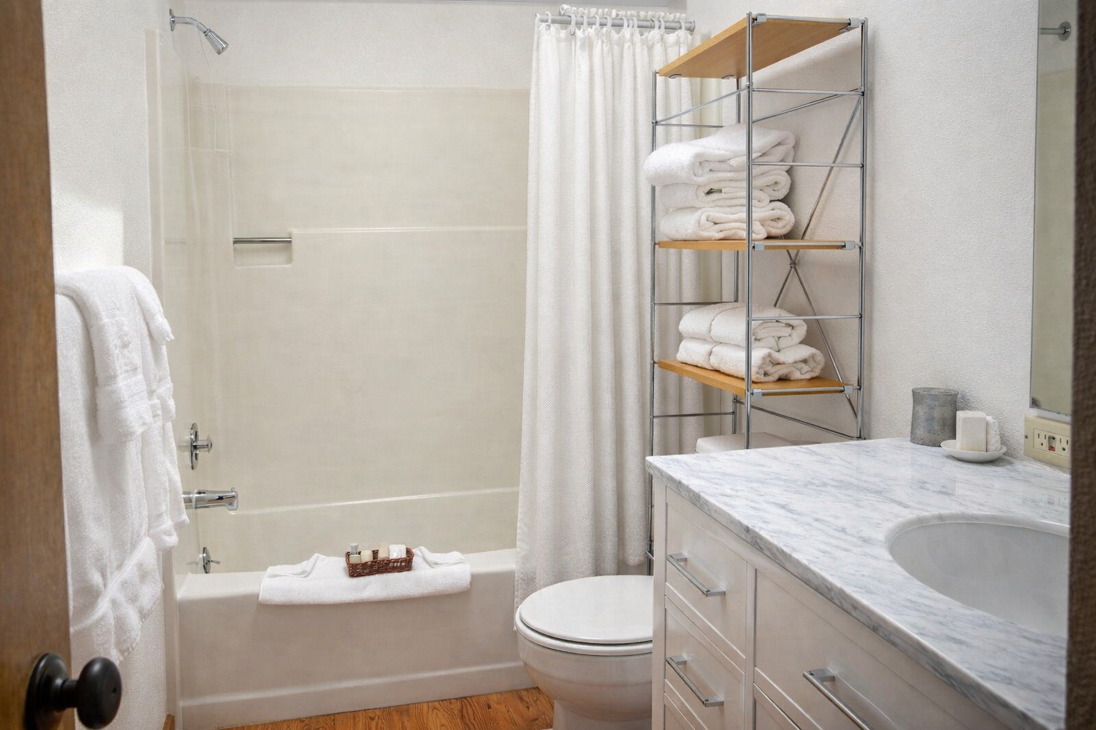Unwind in your pristine bathroom featuring a deep soaking tub, marble vanity, and fluffy towels perfectly arranged for your comfort.