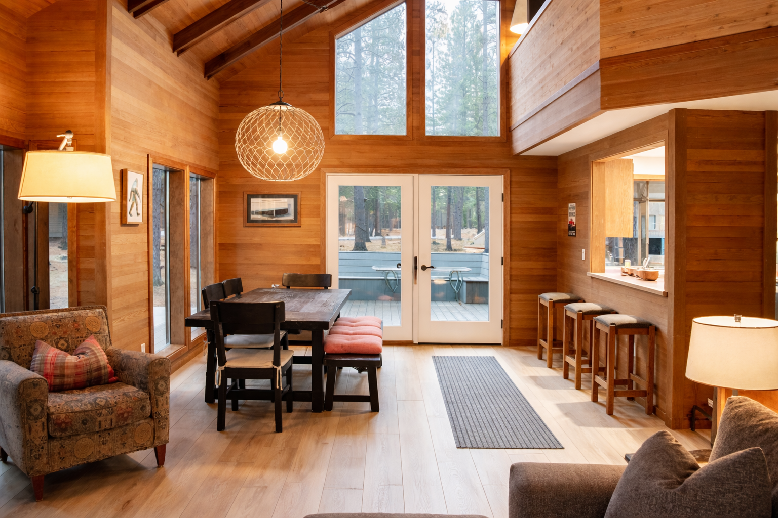 Warm wood walls embrace your open living space where natural light floods through forest views, creating the perfect mountain retreat atmosphere.