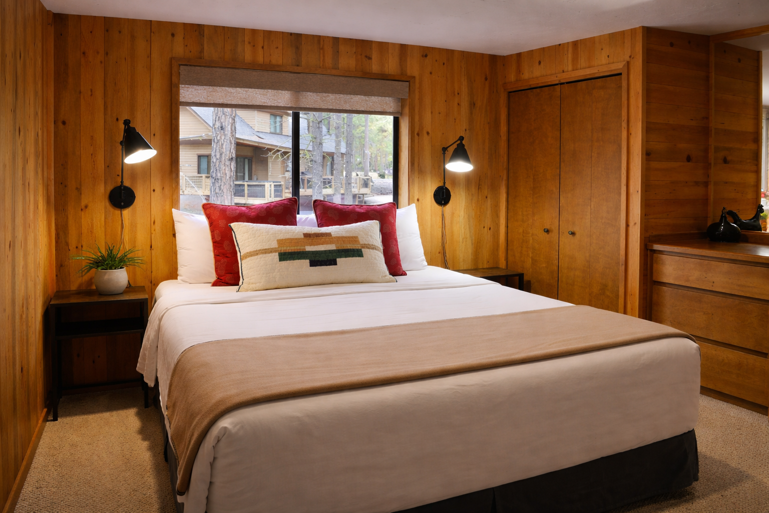 Unwind in your cozy bedroom featuring warm wood walls, crisp linens, and modern wall sconces that create the perfect mountain retreat ambiance.