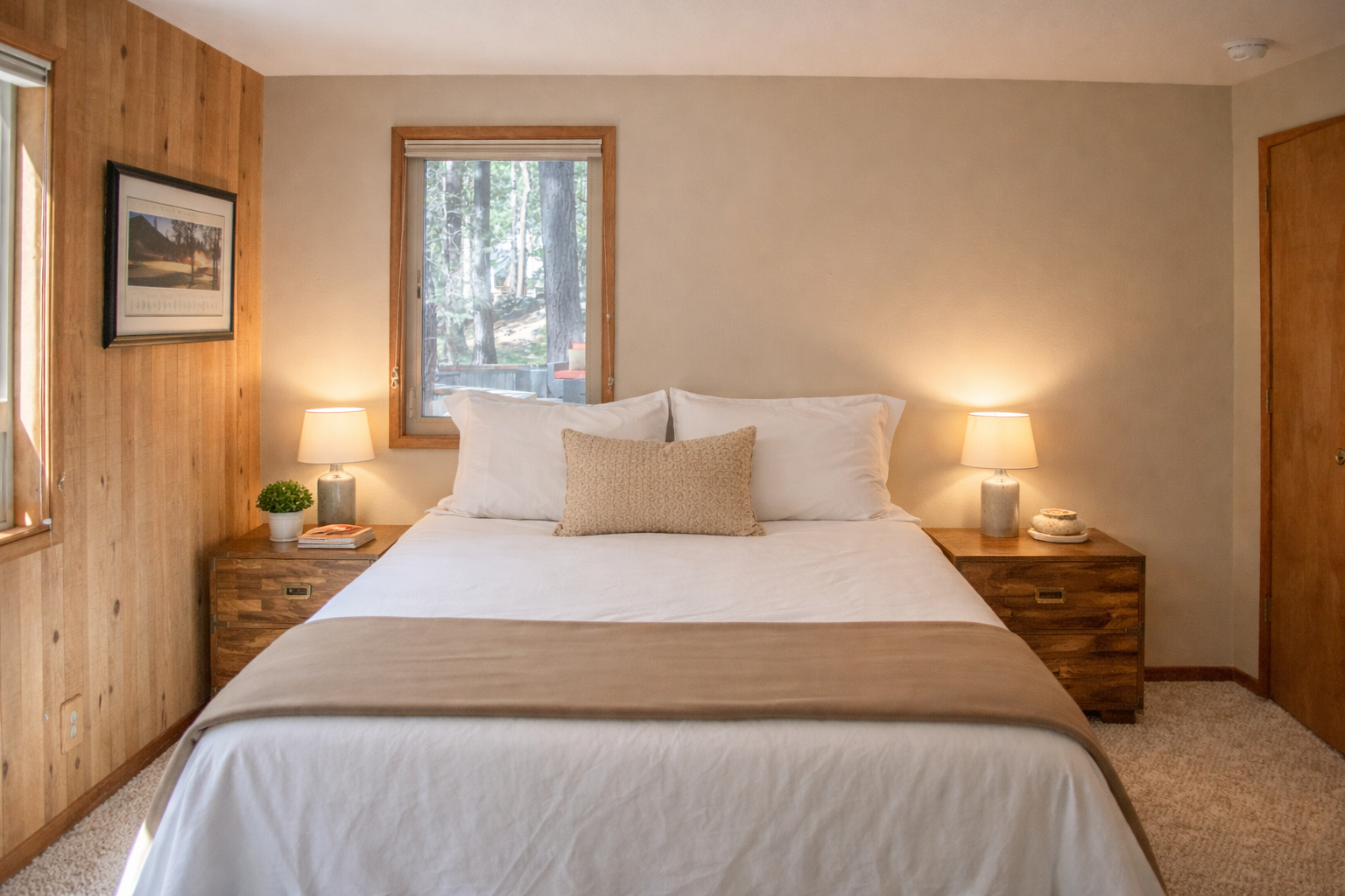 Sink into crisp white linens and enjoy forest views from your serene bedroom retreat, complete with warm wood accents and gentle bedside lighting.