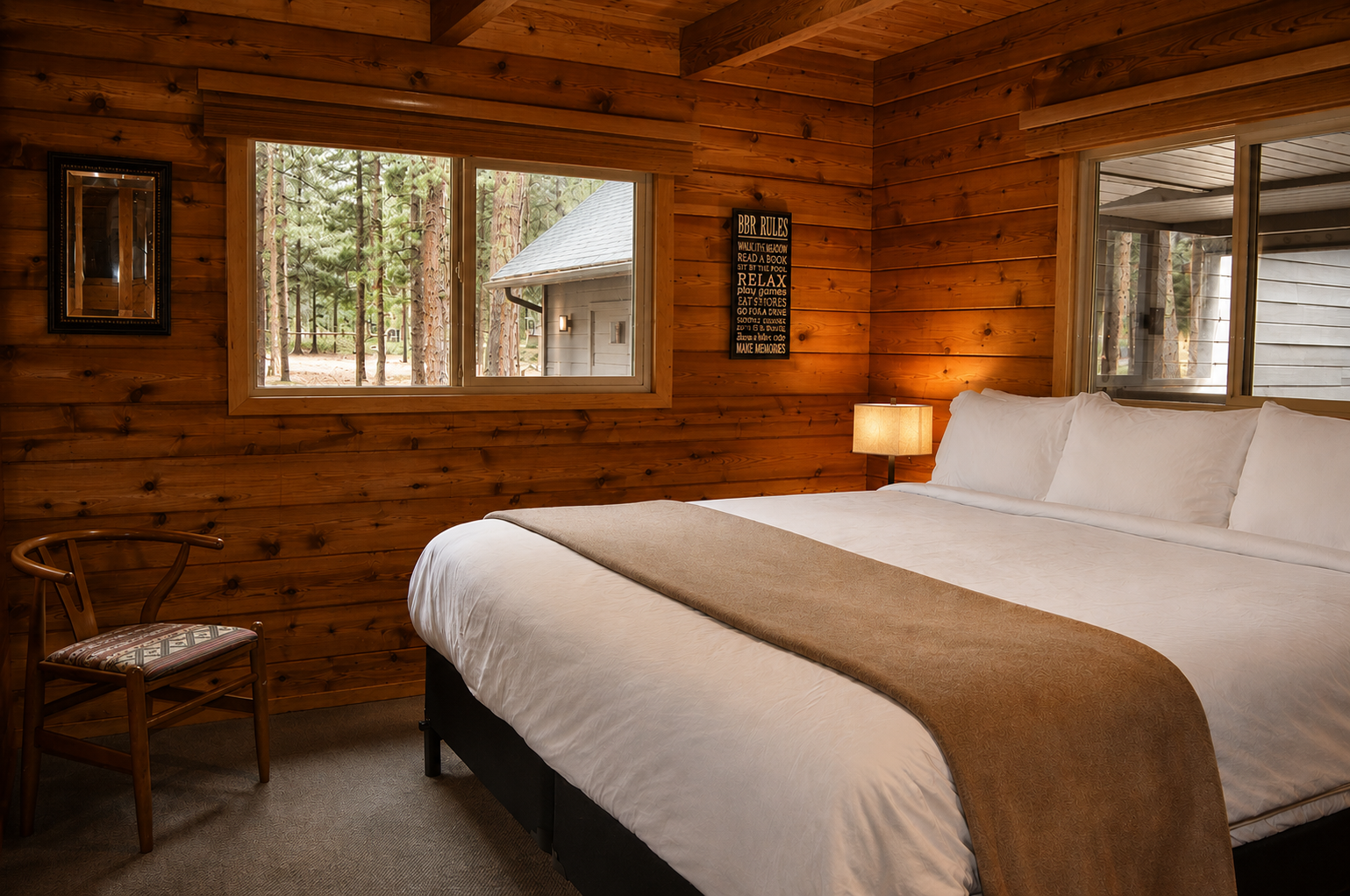 Your cozy retreat awaits with warm wooden walls, a plush king bed, and windows framing the pines—perfect for unwinding after forest adventures.