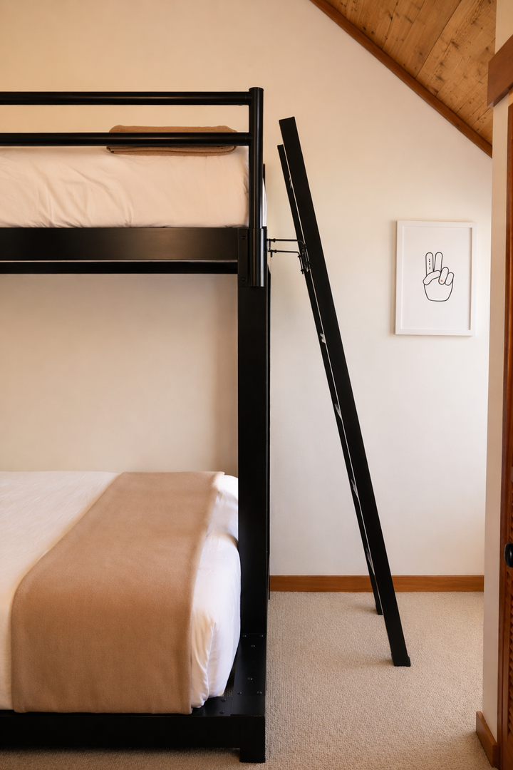 Your cozy attic retreat features stylish bunk beds perfect for families, with exposed wooden beams adding rustic charm to your restful sanctuary.