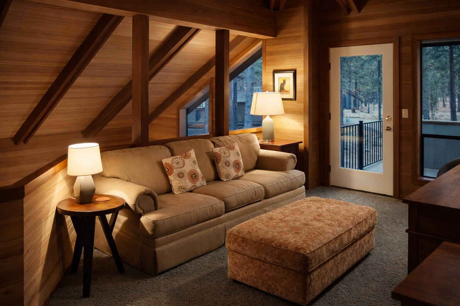 Unwind in your cozy mountain cabin living room with exposed beams, soft lighting, and forest views through the glass doors.