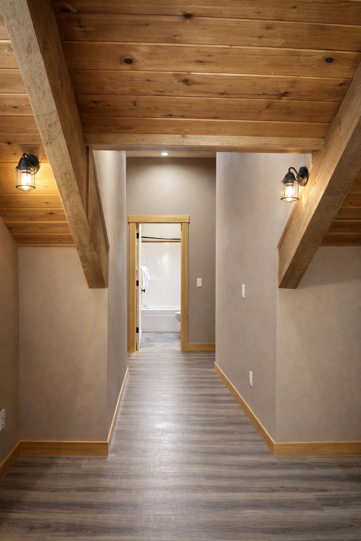 Step into your rustic retreat where exposed wooden beams and warm lantern lighting create an inviting mountain lodge atmosphere.