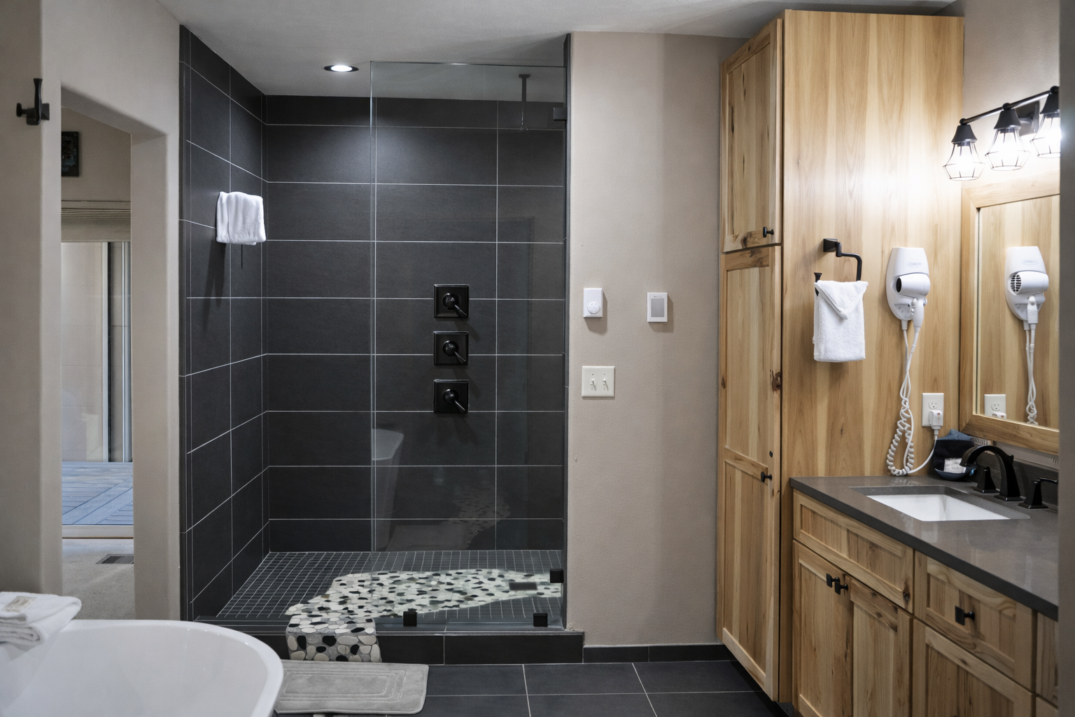 Unwind in your spa-like bathroom featuring a sleek walk-in shower, warm wood cabinetry, and thoughtful amenities for ultimate relaxation.