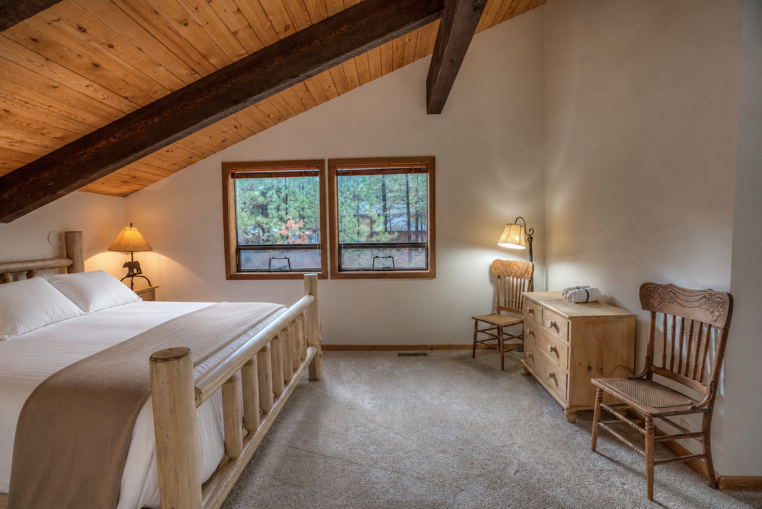 Your tranquil retreat with vaulted wood ceilings, rustic beams, and forest views through twin windows. Rest in the cozy bed, unwind in the rocking chair, and feel nature surround you.