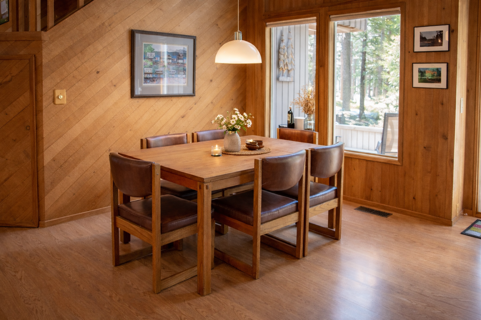Gather around this warm wooden dining table where intimate meals and conversations unfold beneath the gentle glow of pendant lighting.