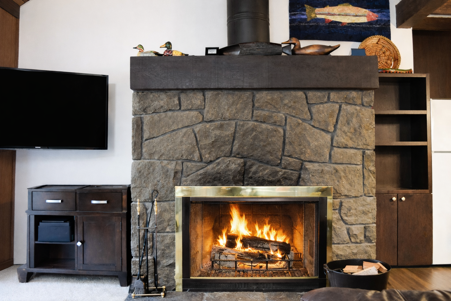 Cozy up by your crackling stone fireplace while watching TV in this inviting living room retreat.
