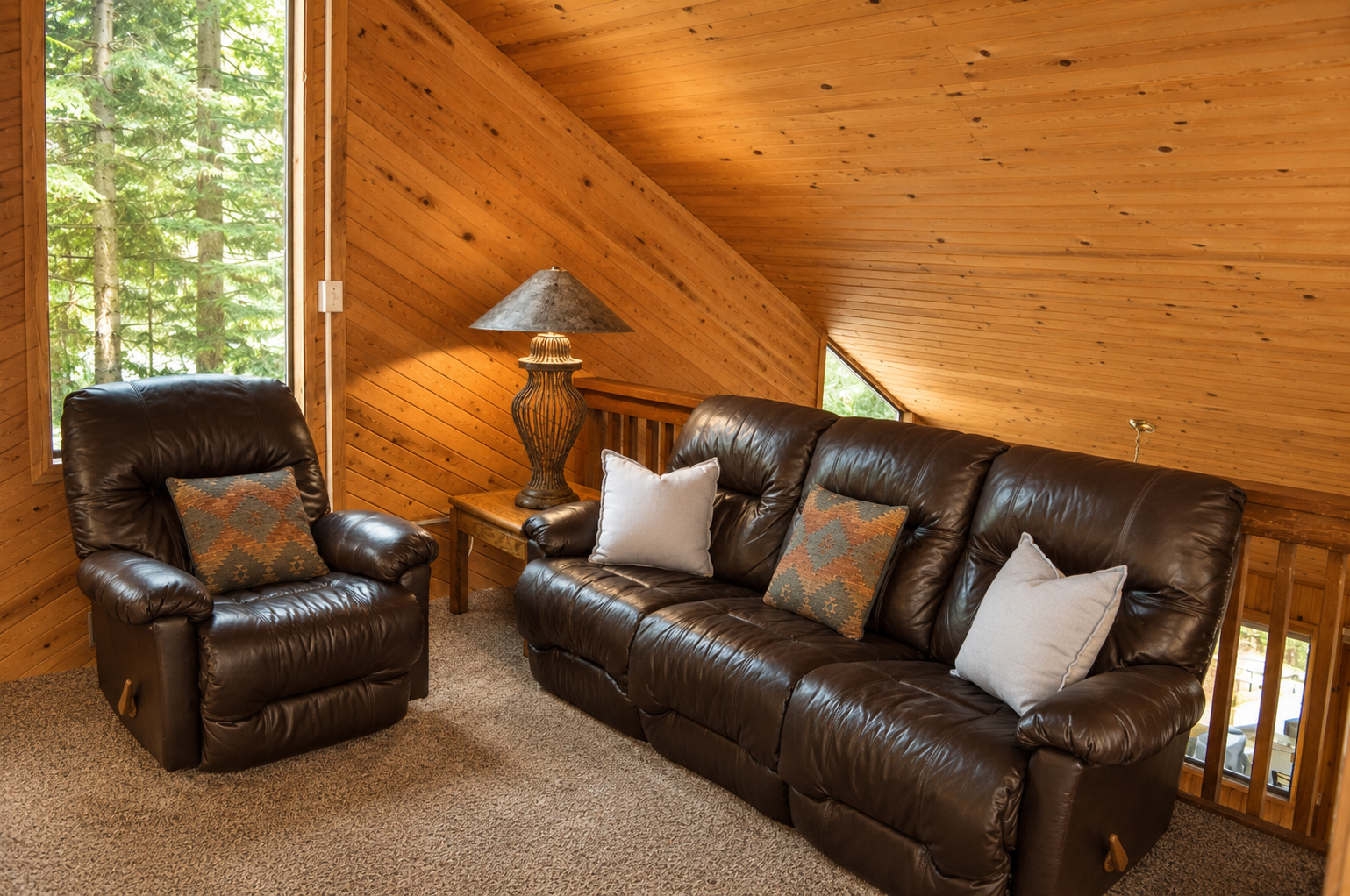 Settle into this cozy loft lounge, where rich leather seating and warm wood envelop you. Relax by the window as sunlight filters through the trees, inviting your peaceful mountain retreat.