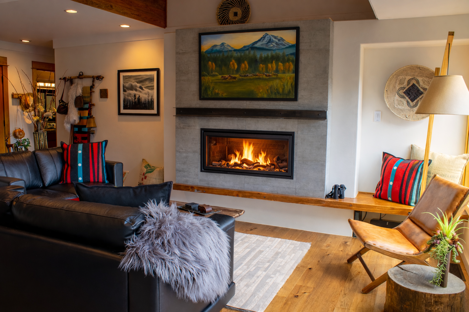 Cozy up by your crackling fireplace with plush seating and mountain artwork creating the perfect retreat atmosphere.