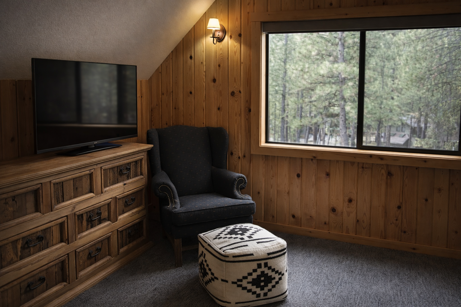 Curl up in your cozy armchair and enjoy nature views through the large window, with warm wood walls creating the perfect cabin retreat.