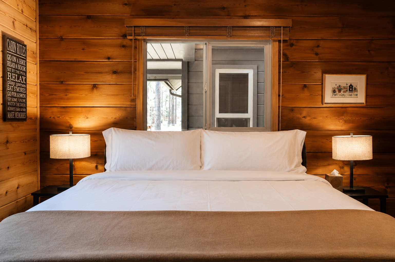 Sink into crisp, white linens surrounded by warm, natural wood walls that invite you to truly unwind. The gentle glow of bedside lamps creates the perfect ambiance for your peaceful retreat.