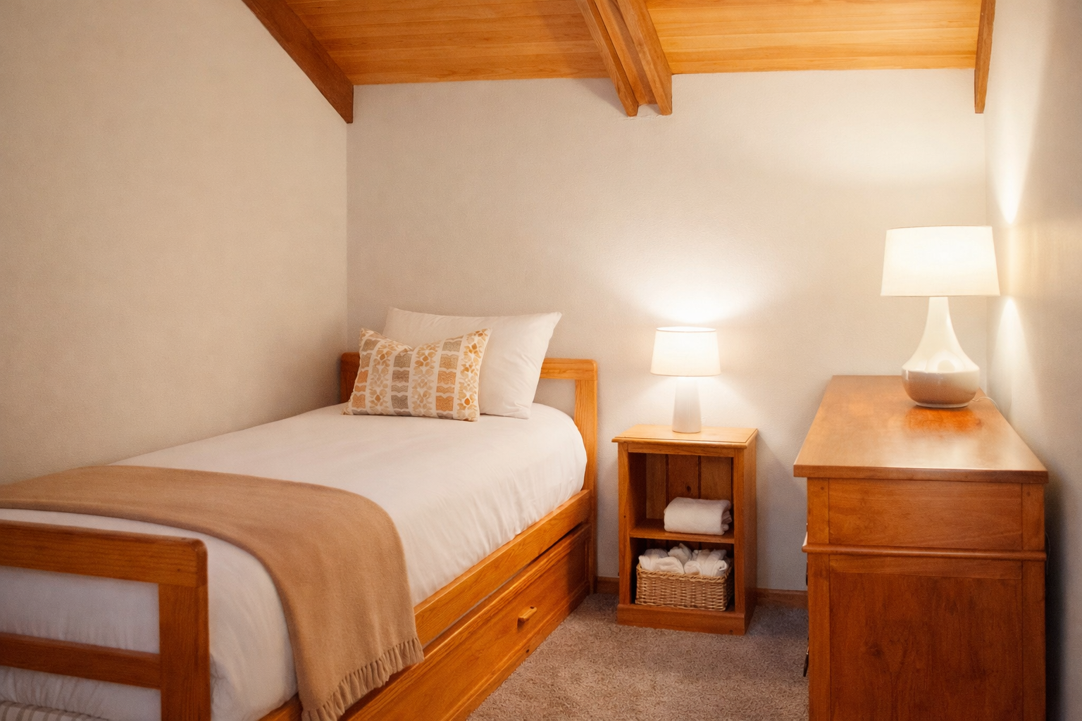 Drift into peaceful slumber beneath warm wooden beams in this cozy bedroom, where crisp linens and thoughtful touches create your perfect retreat.