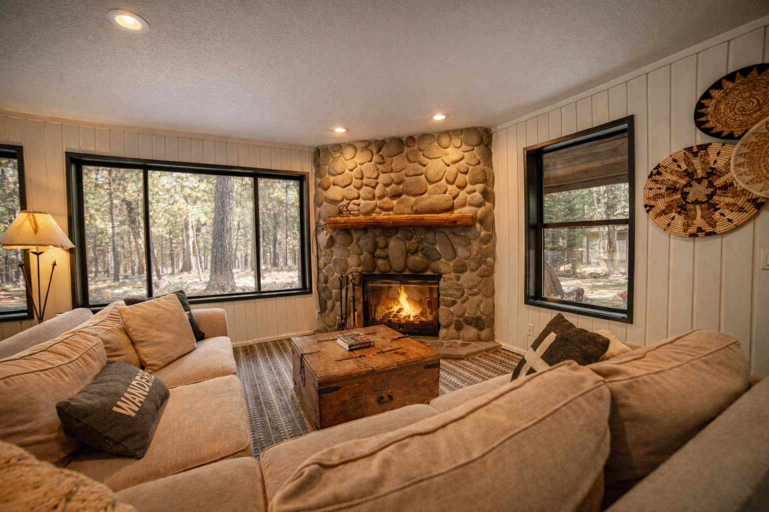 Cozy up by your crackling stone fireplace with forest views surrounding your comfortable living space.