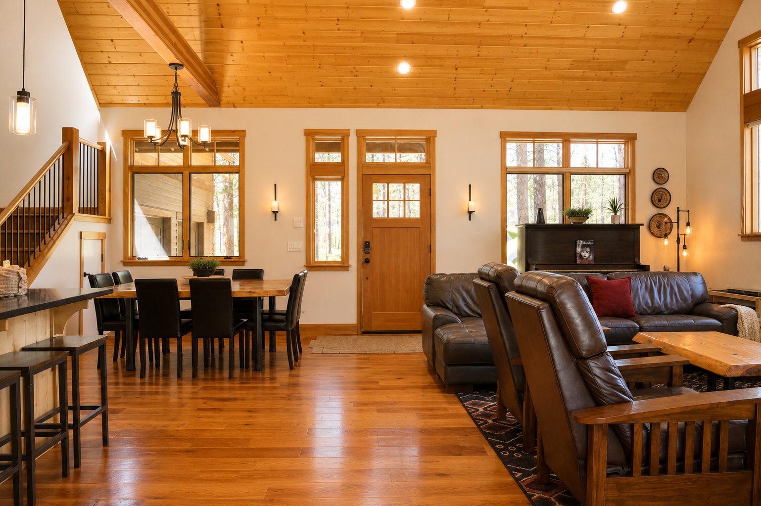 Relax in your inviting open-concept living space, where warm wood tones and soaring ceilings create a mountain retreat feel. Natural light pours through expansive windows as you gather around the cozy leather sectional or share meals at the spacious dinin
