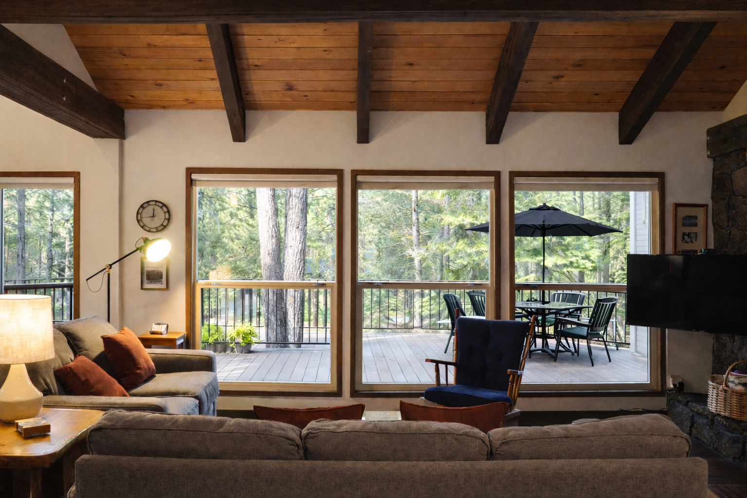 Sink into plush seating with forest views streaming through expansive windows. Your private deck awaits with dining space among towering trees.