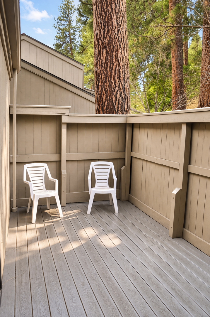 Step onto your private deck surrounded by towering pines, where two cozy chairs await your morning coffee or evening wind-down.
