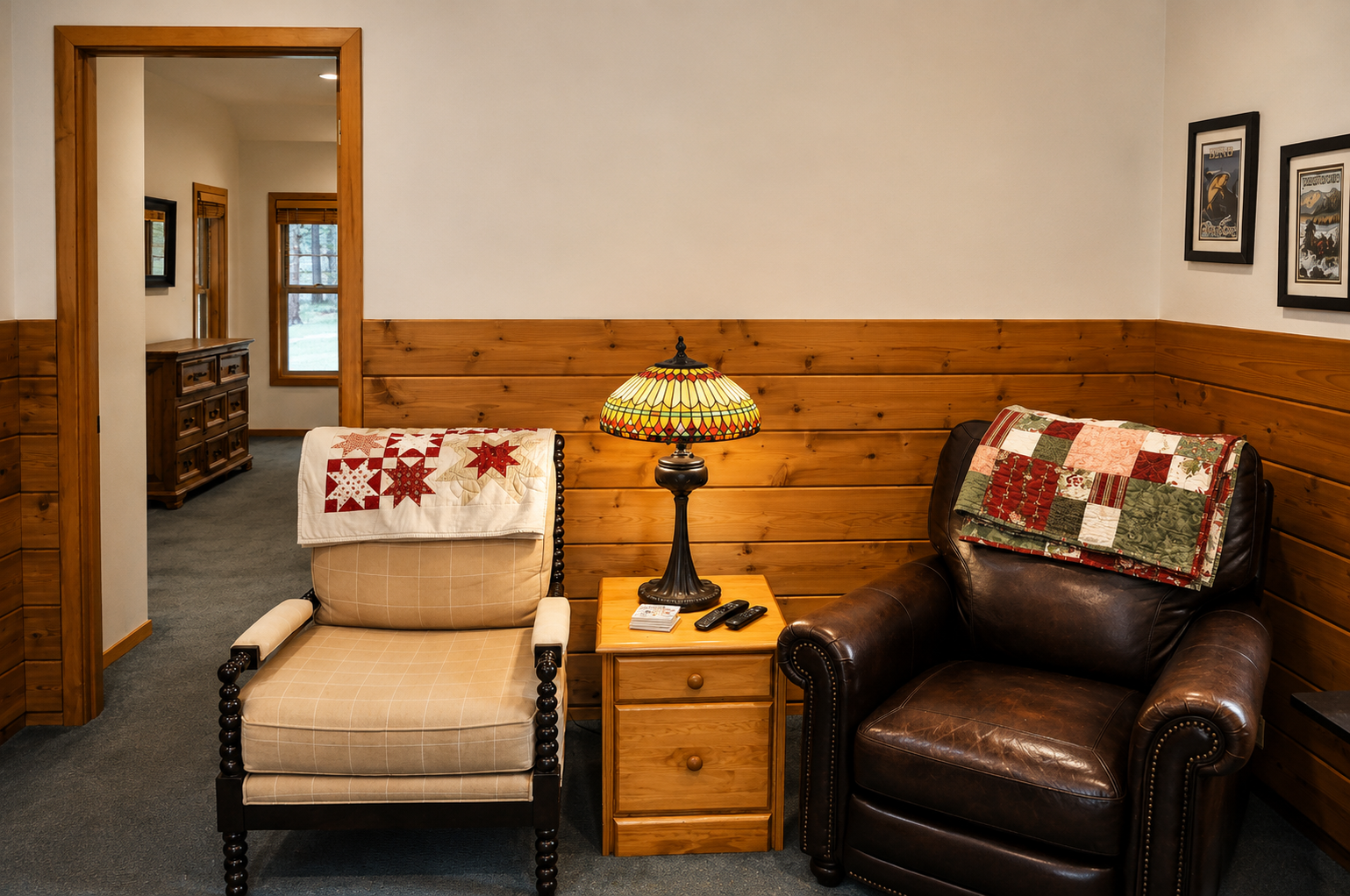 Sink into cozy armchairs and warm wood paneling in your inviting living space, where handmade quilts and a Tiffany-style lamp add charming, homey touches.