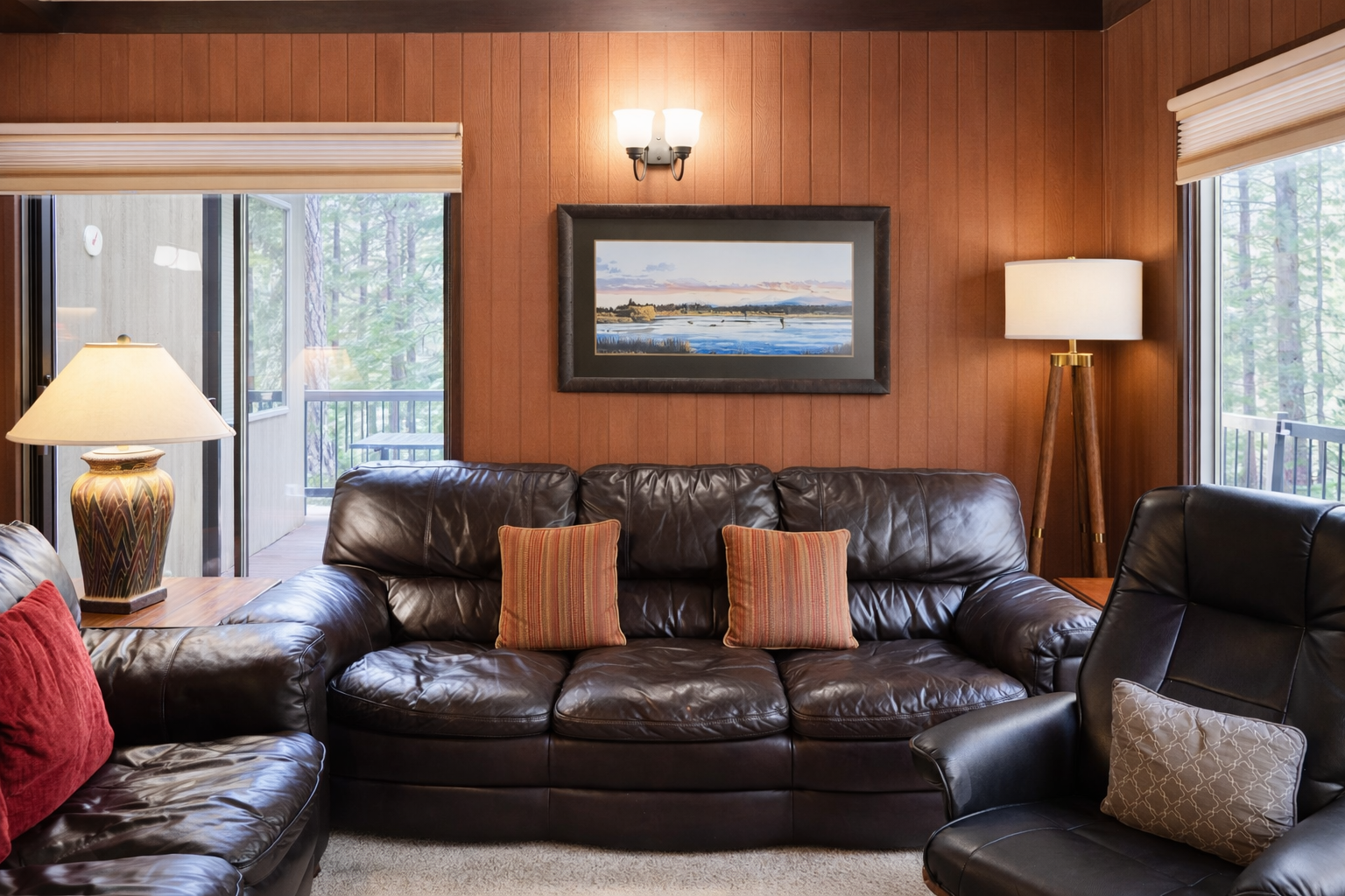 Sink into plush leather seating surrounded by warm wood paneling, where natural light streams through forest views and cozy lighting creates your perfect retreat.